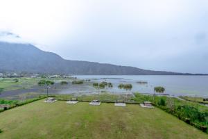a view of a field with chairs and a body of water at The Joglo Beratan in Bedugul +102 photos
