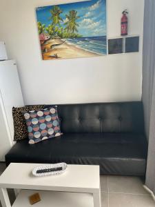 ein Wohnzimmer mit einem schwarzen Sofa und einem Tisch in der Unterkunft Rosales in Playa Blanca