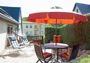 - une table et des chaises sous un parasol sur la terrasse dans l'établissement Ferienwohnung Hanna, à Sellin