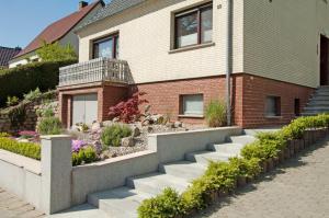 a house with a retaining wall and stairs at Ferienwohnung Hanna in Ostseebad Sellin