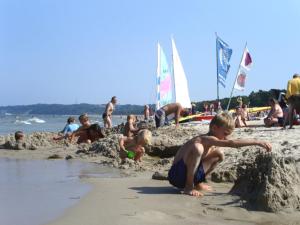 a group of people playing in the sand at the beach at Ferienwohnung Hanna in Ostseebad Sellin