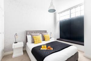 a bedroom with a bed with a tray of food on it at Elliot Oliver - Stylish 2 Bedroom Town Centre Apartment in Cheltenham