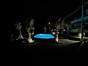 a swimming pool at night with trees and lights at Villa Alba Appartamenti in Kamma