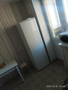 ヨシュカル・オラにあるApartment on Stroiteley streetの冷蔵庫、テーブル、窓が備わる客室です。