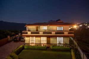 a large house at night with a yard at Hidden Heaven in Coonoor