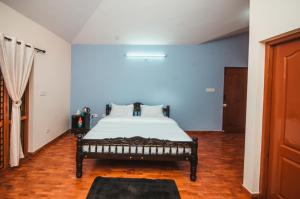 ein Schlafzimmer mit einem Bett in einem Zimmer in der Unterkunft Hidden Heaven in Coonoor