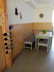 Habitación con mesa, banco y botellas de vino en Ubytování v soukromí en Tvrdonice