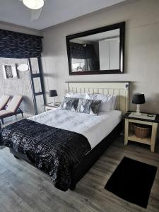 a bedroom with a large bed and a mirror at Whale Rock 29, The ultimate beach living experience. in Margate