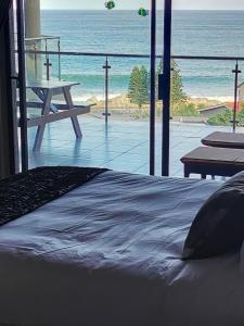 a bed in a room with a view of the beach at Whale Rock 29, The ultimate beach living experience. in Margate