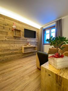 a living room with a wooden wall with a flat screen tv at Casa Cecilia in Bormio