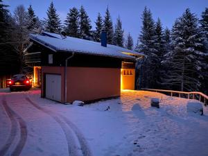 Sondernach的住宿－CHALET DE MANU，停在雪地的建筑物前面的汽车