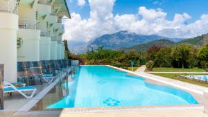a pool at a hotel with mountains in the background at Miarosa Kemer Beach in Kemer