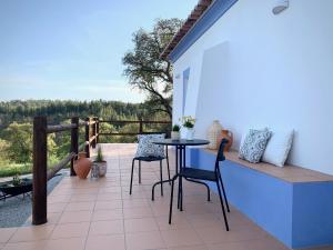 un patio con tavolo e sedie sul balcone. di Monte da Rocha a Santiago do Cacém