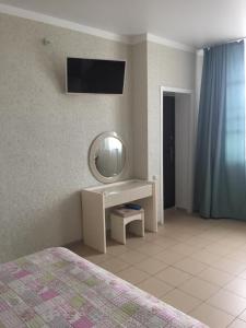 a bedroom with a vanity with a mirror and a tv at Gostinyy dvor in Elista