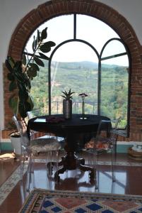 Casa Marelli في كاستيلموتْسْيو: طاولة وكراسي في غرفة مع نافذة كبيرة