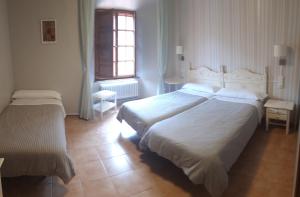 Cette chambre comprend 2 lits et une fenêtre. dans l'établissement MONASTERIO de SANTA MARÍA DE VALVANERA, à Anguiano