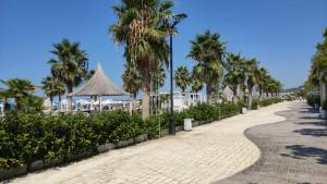 una calle adoquinada con palmeras y una playa en J&A Beachside Apartment, en Golem