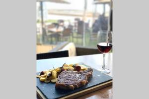 a steak on a plate next to a glass of wine at Lovely and luxury apartament in front of the beach in Los Alcázares