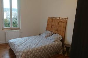 a bedroom with a bed and a large window at Les lunettes d'Oyo in Oyonnax