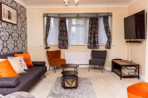 a living room with a couch and a tv at Burnham House - LABRAD HOMES in Burnham