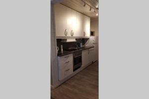 a kitchen with white cabinets and a stove at Dallavaraveien 4 in Vadsø +7 photos