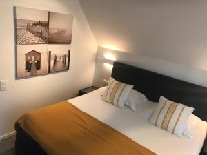 1 dormitorio con 1 cama y 2 cuadros en la pared en VILLA FER-GUY " Beeldige Suite met parking, nabij strand en casino" en Knokke-Heist