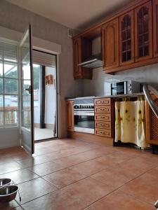a kitchen with wooden cabinets and an open door at Casa Rubén Darío in Villarejo del Valle +29 photos