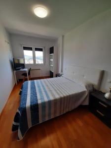 フォスにあるLugomarのベッドルーム1室(青と白の毛布付きのベッド1台付)