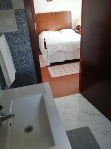 a bathroom with a sink and a bedroom with a bed at Varandas da Serra II in Vila Franca de Xira