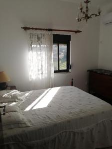 a bedroom with a large bed with a window at Varandas da Serra II in Vila Franca de Xira