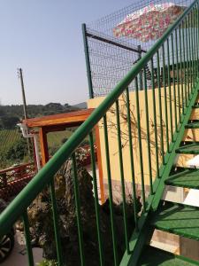 una escalera con una barandilla verde y una sombrilla en Varandas da Serra II, en Vila Franca de Xira