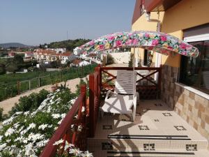 a patio with an umbrella and a chair on a balcony at Varandas da Serra II in Vila Franca de Xira