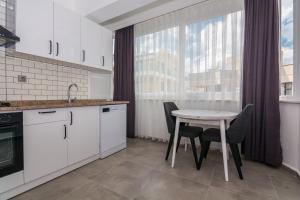 une cuisine avec une table et des chaises ainsi qu'une fenêtre dans l'établissement Seaside Apartments, à Alanya