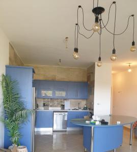 cocina con armarios azules y mesa en einbay 3 bedrooms garden + pool view, en Ain Sokhna