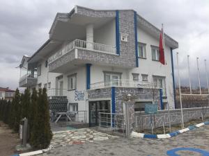 a large white building with blue trim at Cappadocia Symbol Hotel in Uçhisar