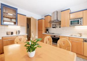 een keuken met houten kasten en een houten tafel met een plant bij Appartement Marlenka in Umhausen