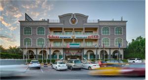 a building with cars parked in a parking lot at Sahara Beach Resort & Spa in Sharjah