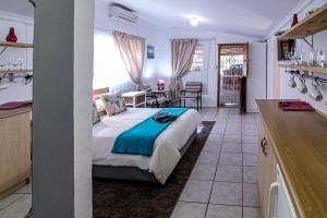 a bedroom with a bed and a kitchen with a table at Eagle's Nest in Graaff-Reinet