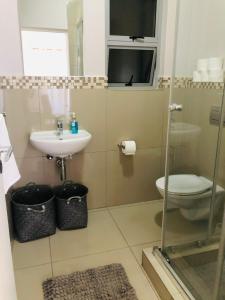 a bathroom with a toilet and a sink at Umhlanga Ridge self-catering apartment in Durban