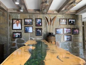 een grote houten tafel in een kamer met foto's aan de muur bij Grand Altunhan Hotel in Svilengrad