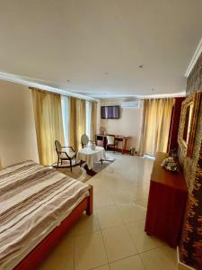a hotel room with a bed and a table and chairs at Penzion Vegas in Partizánske