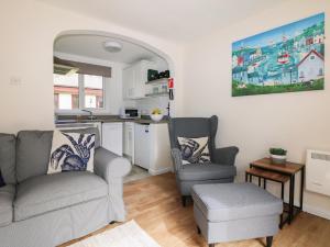 a living room with a couch and two chairs and a kitchen at Miles Retreat in Hayle