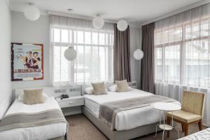 a bedroom with two beds and a table and chairs at Delight Deluxe Port in Antalya