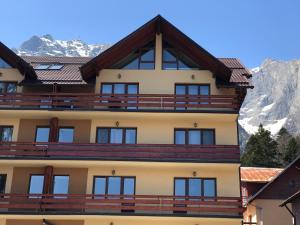 a building with mountains in the background at Chic Peak Apartment - Kalinderu Slope & View in Buşteni