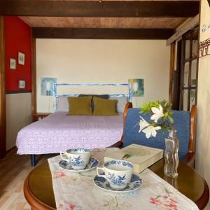 a bedroom with a bed and a table with two cups at Son de Mar Hotel rural & Apartamento in Quintueles
