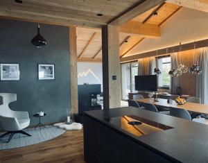 a kitchen and living room with a table and chairs at Florisa Mountain Penthouse in San Vigilio Di Marebbe