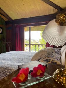 Son de Mar Hotel rural & Apartamento في Quintueles: غرفة نوم مع سرير مع طاولة عليها زهور