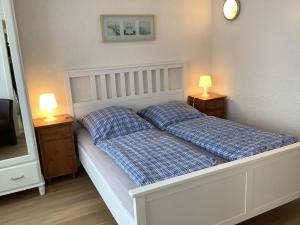 1 cama con 2 almohadas en un dormitorio con 2 lámparas en Pension Villa Wolkenlos, en Dahme