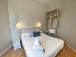 ein Schlafzimmer mit einem weißen Bett und Handtüchern darauf in der Unterkunft MIRADOR DEL TRANSITO in Toledo