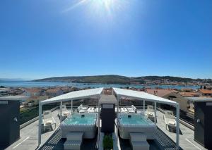 Blick auf einen Pool mit Stühlen und das Meer in der Unterkunft Sky Garden Trogir in Trogir